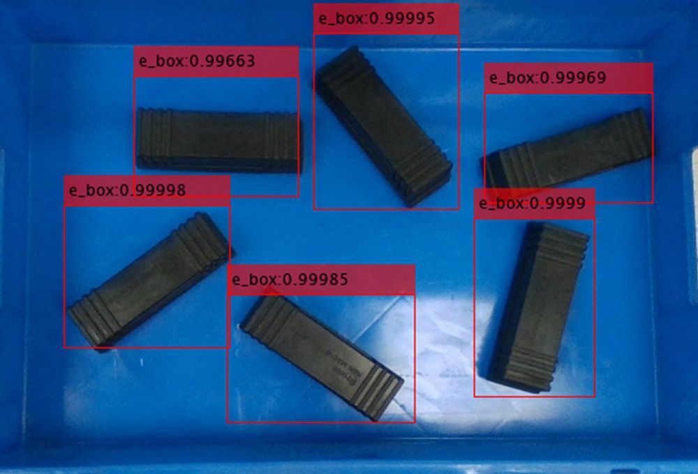 Seis cajas negras en un contenedor identificadas mediante YOLO y etiquetadas con probabilidad para permitir la selección y empaquetado por un cobot.