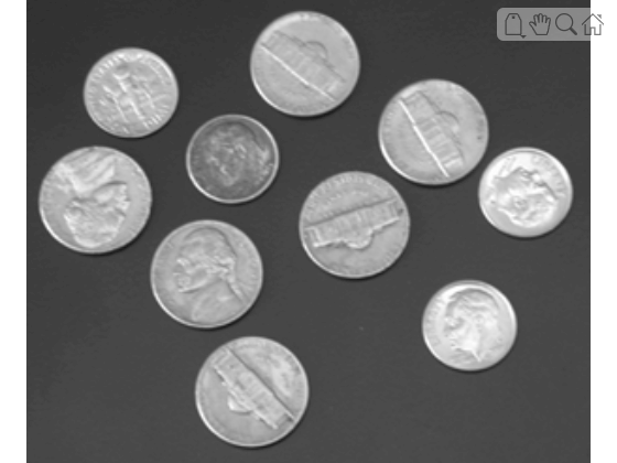 Grayscale image with several nickels and dimes scattered on a dark gray background