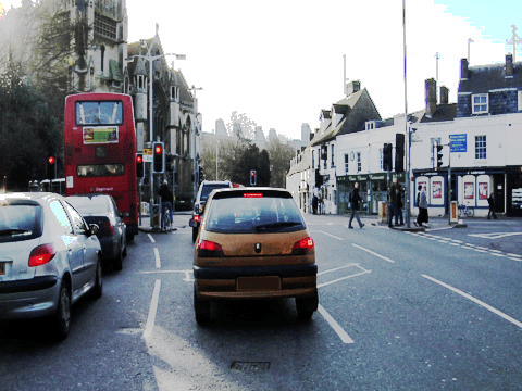 RGB image of a street scene with vehicles, traffic lights, and pedestrians